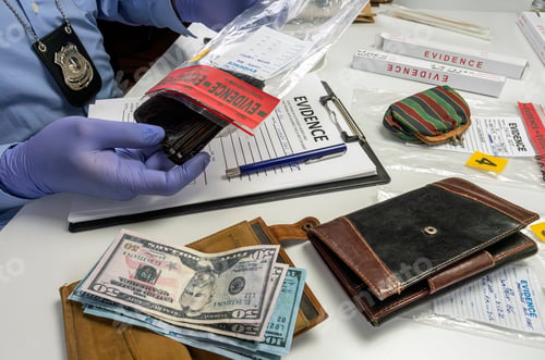 Preview: Specialised police officer takes wallet with money out of a murder evidence bag, conceptual image