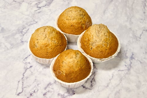 Preview: Closeup of freshly-baked muffins on a marble countertop