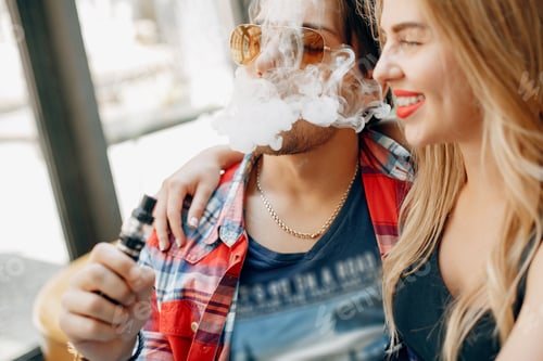 Preview: Stylish young couple with vape in a cafe