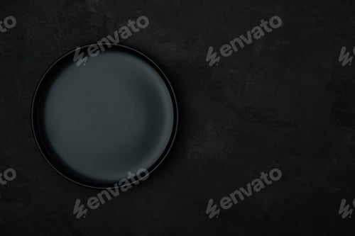 Preview: Empty plate. Dark black ceramic empty plate on dark black stone background.