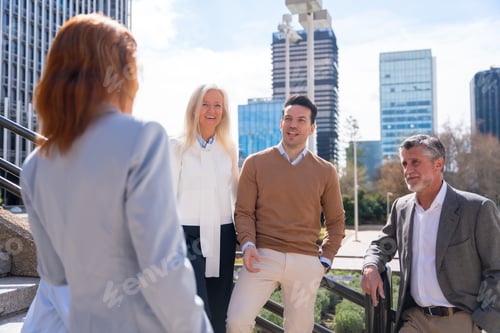 Preview: Cheerful group of coworkers outdoors in a corporate office area resting