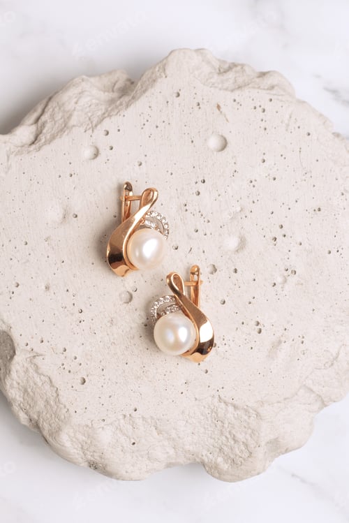 Preview: Gold earring with pearl on concrete podium