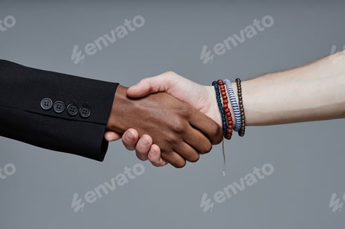 Preview: Caucasian Young Adult Man and Black Woman Shaking Hands in Studio