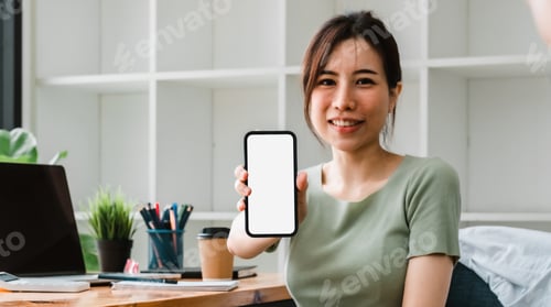 Preview: Beautiful asian woman showing mobile phone with blank white screen at her office. business