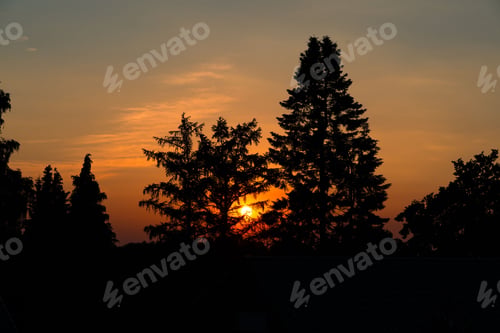 Preview: Idyllic landscape with a golden-orange sunset glowing in the background