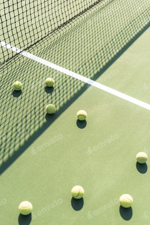 Preview: close up view of tennis balls and net on tennis court