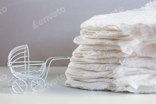 Preview: Baby diapers with a toy carriage on a white background