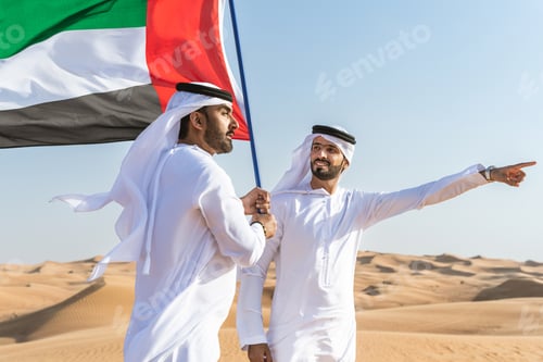 Preview: Two middle-eastern emirati men wearing arab kandura bonding in the desert