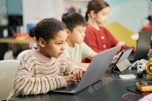 Preview: Young Students Engaging in Learning Activities on Laptops