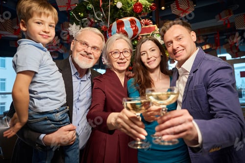 Visualização: Família comemorando as férias de Natal brindando com taças de champanhe