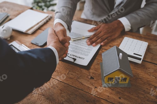 Preview: Real estate broker and client shaking hands after signing sale contract, home loan and congratulatin