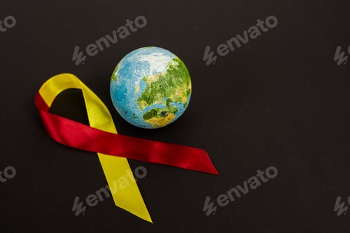 Preview: globe near red and yellow ribbon as hepatitis c awareness isolated on black