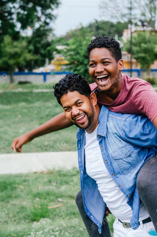 Preview: Dominican Latino man celebrating father's day with his children in the park, father carrying his son