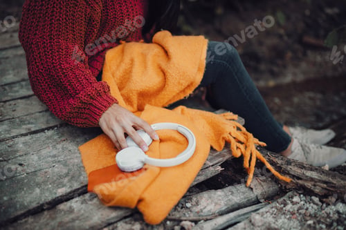 Preview: Young woman seating in an small wooden bridge in the forest