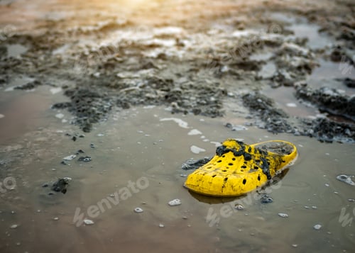 Preview: very dirty yellow Shoe on the shore of a salt lake on a Sunny day.