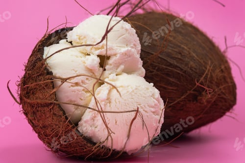 Preview: Vanilla ice cream balls in an empty coconut decorated with mint leaves on a pink background