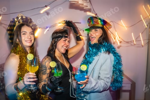 Preview: Friends celebrating a costume party at home with cocktails