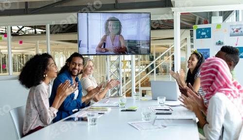 Preview: Happy diverse business people applauding during video conference at conference room