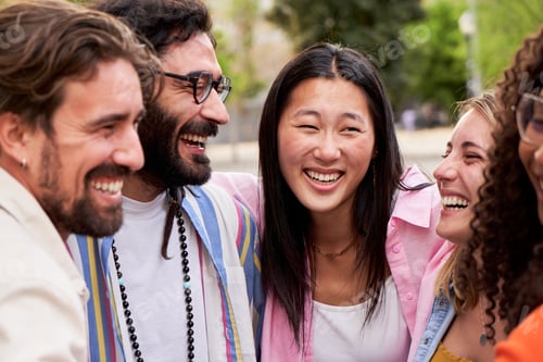Preview: Multicultural group of friends looking at each other smiling while embracing in circle outdoors.