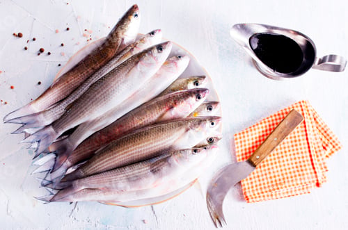 Preview: raw fish with spice on plate and on light table