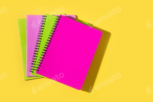 Preview: Bright school supplies, notebooks on yellow. Top view, flat lay. Copy space.