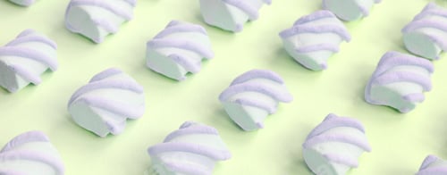Preview: Colorful marshmallow laid out on lime paper background. pastel creative textured pattern