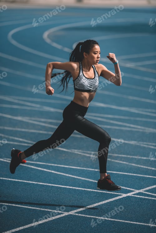 Preview: asian sportswoman training on running track stadium, young girl running concept