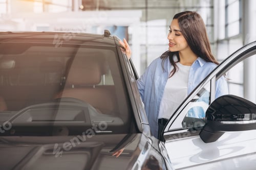 Preview: Happy friendly woman customer buyer client wears blue shirt stand inside car dealership chooses auto