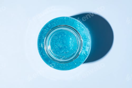 Preview: blue bubble skin care cream gel in a glass jar top view. Beauty treatment product texture macro.