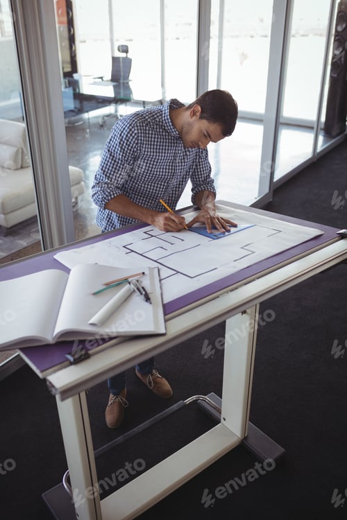 Preview: Focused interior designer planning on paper in creative office