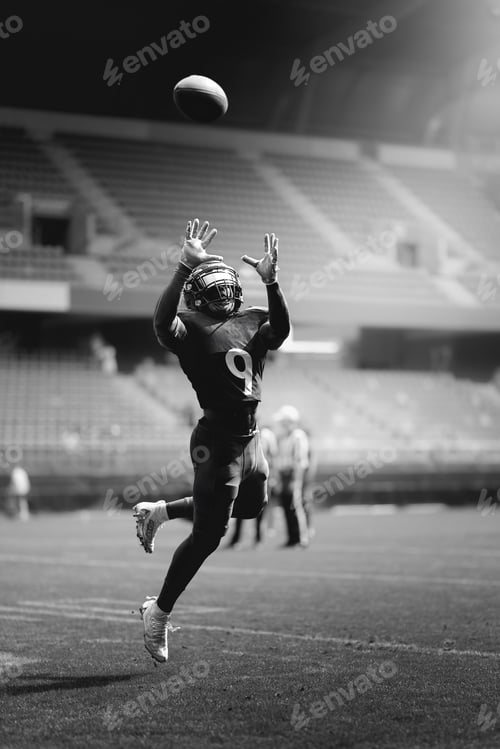 Preview: Football player catching ball in empty stadium.