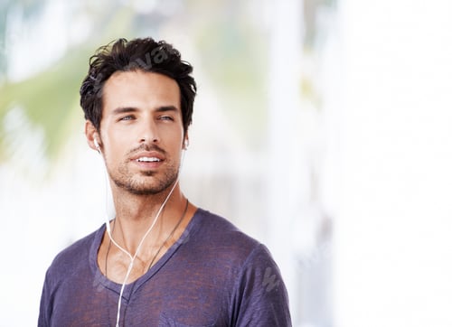 Preview: Shot of a handsome man listening to music and looking deep in thought