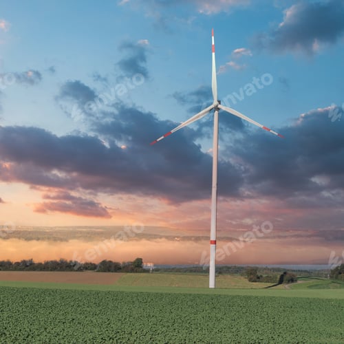 Preview: Scenic view of a windmill in an open green field at a beautiful cloudy sunset