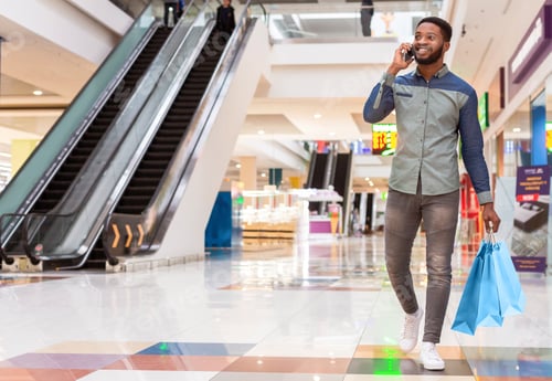 Preview: Black Man Walking Through Shopping Mall While Talking on Phone
