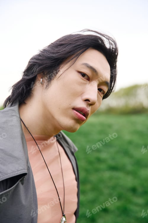 Preview: Young man showcases trendy style in park during sunny afternoon