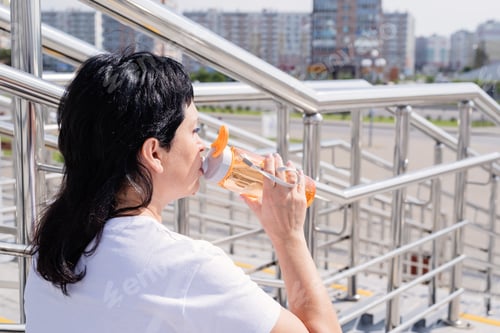 Preview: Woman Drinking Water from Bottle on Stairs