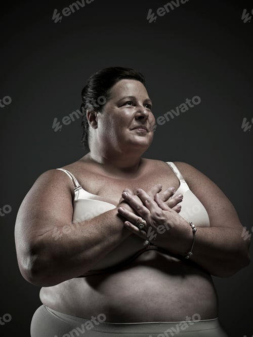 Preview: Confident woman posing with hands on heart in a studio setting