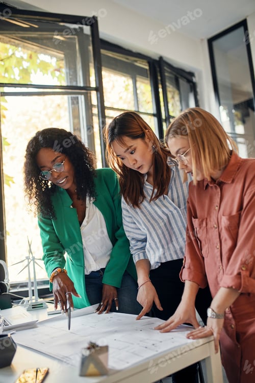 Preview: Businesswomen having a meeting in office with wind turbine models on table