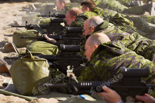 Preview: Training for war. Shot of a group of soldiers aiming their rifles while lying on the ground.