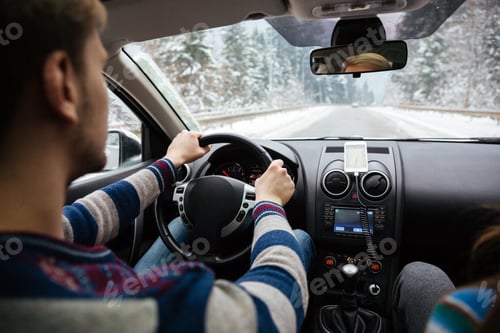 Preview: Handsome young driver driving through winter forest