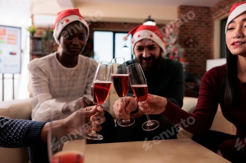 Visualização: Pessoas tilintando taças de vinho na festa de escritório de Natal