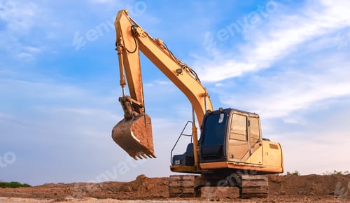 Preview: Yellow excavator is leveling the ground in construction site against blue sky background