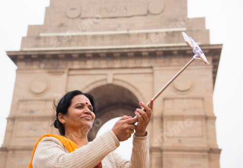 Preview: Tourist taking selfie with smart phone in front of India Gate, Delhi, India.