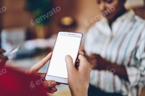 Preview: Person browsing smartphone at table on multiracial meeting