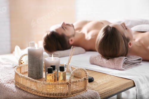 Preview: Young couple with spa essentials in wellness center