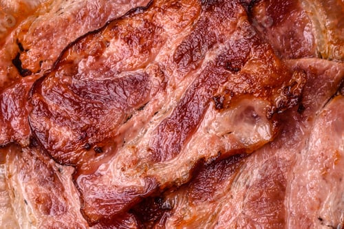 Preview: Cooked fried crispy bacon as an ingredient of a delicious English breakfast. Pieces of fried bacon