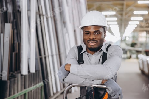 Preview: Factory worker leaning on a pallet jack in a warehouse of aluminum and PVC windows and doors