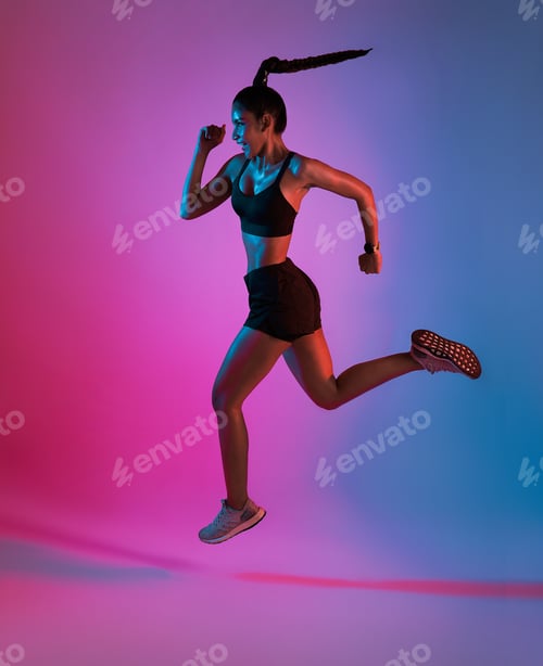 Preview: Athlete asian sportswoman running as part of fat burning workout in fitness studio neon background.