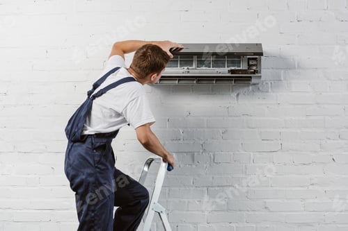 Preview: rear view of air conditioner repairman standing on stepladder