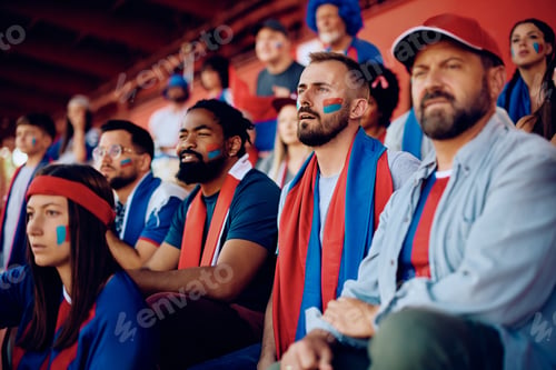 Preview: Group of male friends spectating sports game from stadium stands.